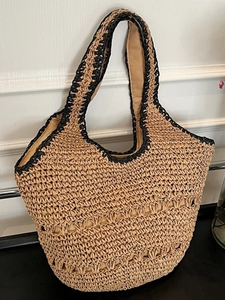 Handmade woven straw tote bag with black contrast trim for summer beach vacation