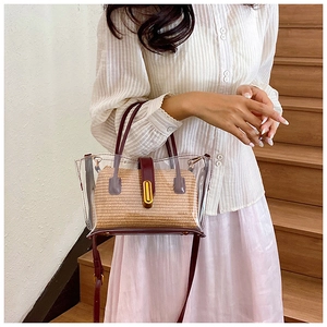 Détail du sac cabas en PVC transparent avec pochette tissée et lanières en cuir rouge