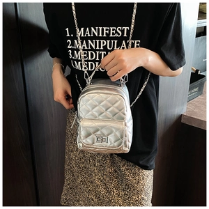 Detail des silbernen Metallic-Mini-Rucksacks mit Rautenmuster, Kette und Drehverschluss