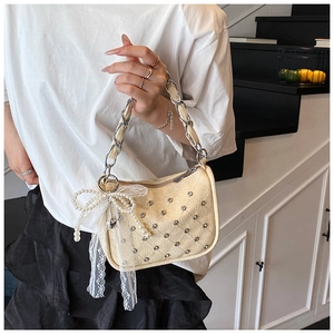 Détail du sac à bandoulière matelassé avec clous, pendentif noeud et bandoulière chaîne