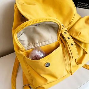 Détail de la poche de sac à dos jaune avec boucle magnétique et cordon de serrage