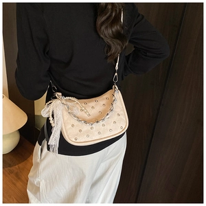Vue détaillée du sac punk crème avec rivets argentés et nœud en dentelle sur un mannequin