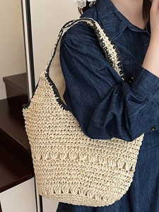 Hollow out woven shoulder bag in beige with black trim for summer beach vacation use