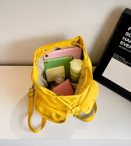 Intérieur spacieux du sac à dos en nylon jaune montrant tablette et objets essentiels