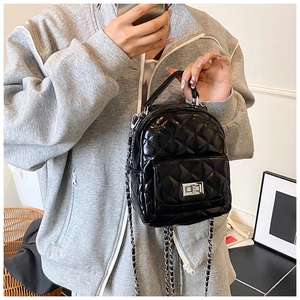 Detailansicht der Mini-Stepptasche aus Lackleder mit silberner Kette und Drehverschluss