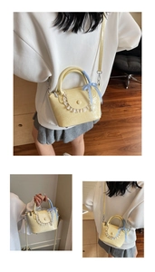 Detail of yellow patent leather handbag featuring lace ruffles and a blue gingham bow
