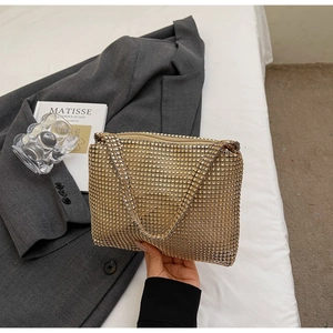 Détail d'une pochette dorée à strass scintillants avec une fine texture de maille