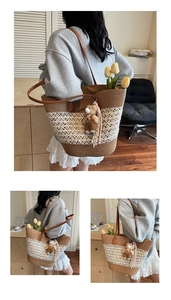 Detail of woven straw tote bag with brown leather handles and a cute bear charm
