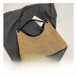 Detail of light brown woven texture with black leather trim on a large beach tote bag