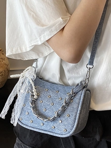 Petit sac punk en denim bleu avec clous argentés, chaîne métal et nœud en dentelle