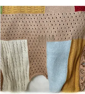 Detailed close-up of colorful crochet knit tote bag with tassel patchwork and hollow weave