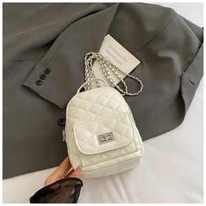Detail eines weißen Stepp-Minirucksacks mit silbernen Metallketten und Drehverschluss