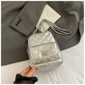 Detail der silbernen gesteppten Mini-Beuteltasche mit Kettenriemen und Drehverschluss