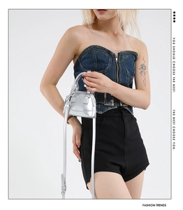 Chic silver mini shell bag with metallic finish shown on model with denim outfit