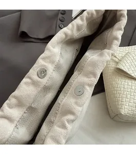Detail of dual magnetic closure and herringbone lining on woven dumpling bag