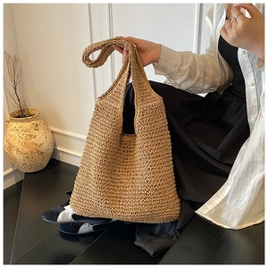 Dettaglio della trama della grande borsa tote in paglia in una scena lifestyle estiva