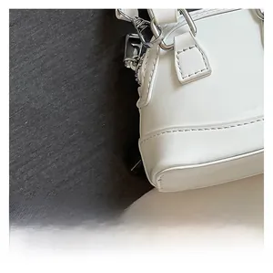 Gros plan détaillé du sac en cuir verni blanc brillant avec accessoires argentés
