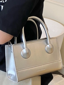 Metallic silver handbag with round top handles and sleek minimalist crossbody design