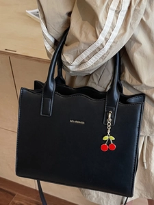 Elegante schwarze Lederhandtasche mit Goldlogo und Kirschanhänger für Damen