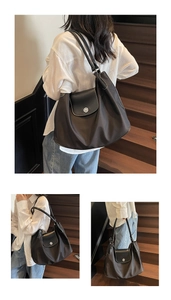 Macro detail of nylon tote bag featuring silver twist lock and white contrast stitching