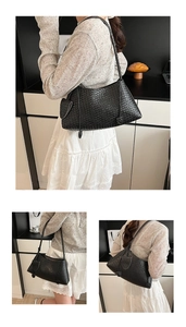 Detail of a black woven leather hobo shoulder bag with a matching mini coin pouch accessory