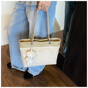 Detail showing the dual-material texture of the tote bag with a cute plush bear charm