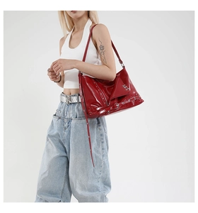 Détail du sac à main en cuir verni rouge avec clous argentés et détails de style biker