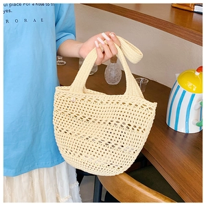 Detail showing the intricate hollow crochet weave texture of this beige summer tote bag