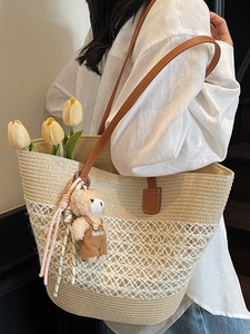 Straw tote bag with brown leather straps and cute bear charm for summer beach trips