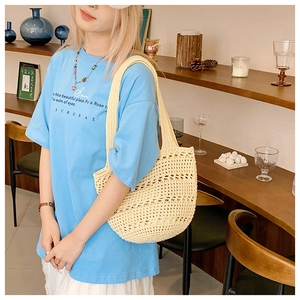 Detailed close-up of ivory crochet hollow knit tote bag with thick woven shoulder strap