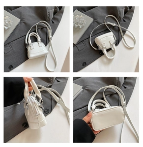 Détails d'un sac coquillage en cuir verni blanc avec fermeture éclair argentée et bandoulière