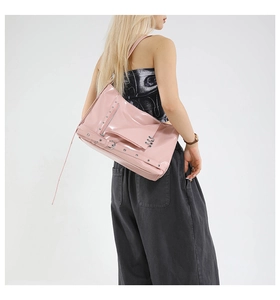 Détail du sac cabas en cuir verni rose avec clous argentés et boucles métalliques