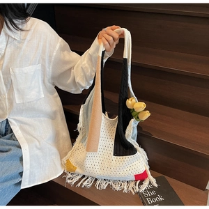 Close-up of bohemian crochet tote bag featuring multi-color patchwork and long tassels