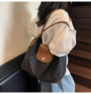 Detailed view of casual large tote bag with black nylon and brown leather strap details