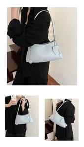 Detail view of woven light blue underarm bag with classic intrecciato texture and strap