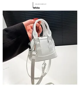 Détail du mini sac coquillage blanc en cuir verni avec bandoulière et boucles argentées