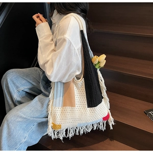 Detail of bohemian knitted tote bag with colorful patchwork and long fringe tassels
