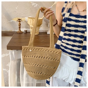 Detailed close-up of khaki crochet woven beach bag with hollow knit design and side button