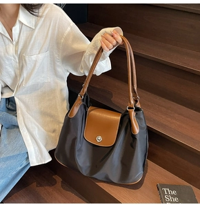 Close-up of contrast color nylon tote bag with leather trim and silver metal buckle