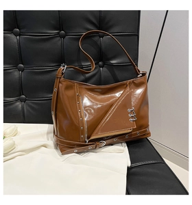 Détail du sac punk marron avec rivets métalliques argentés et anneaux décoratifs