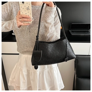 Detail of black woven leather underarm bag showing Intrecciato texture and slim strap