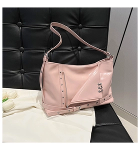 Détail du sac punk en cuir verni rose clair avec rivets métalliques et zips décoratifs