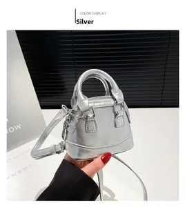 Détail d'un mini sac argenté métallisé avec finition brillante et poignée supérieure chic