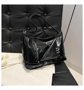Gros plan sur le sac punk noir brillant avec des rivets et des anneaux en métal