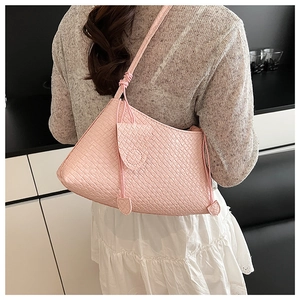Detailed back view of pink woven shoulder bag with unique knotted strap and side pouch