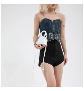Mini white shell bag in glossy patent leather styled on model for a trendy Y2K aesthetic
