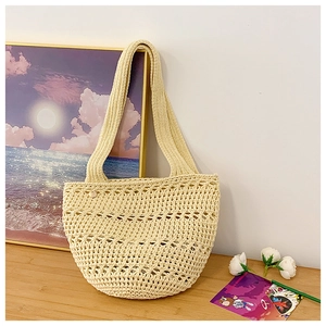 Close-up of cream handmade woven tote bag with intricate hollow geometric mesh texture