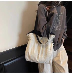 Dettaglio borsa tote in nylon crema con texture trapuntata e chiusura a coulisse regolabile