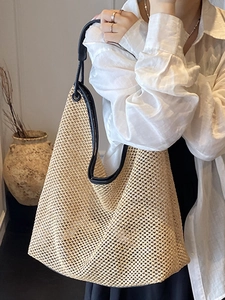 Minimalist woven straw tote bag with black leather straps for summer beach travel