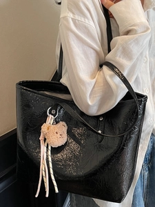 Grande borsa tote nera in ecopelle stropicciata lucida con un ciondolo a forma di orsetto